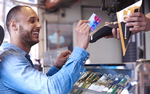 Young man doing contactless payment for fries