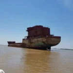 El «barco fantasma» del Paraná volvió a soltarse por la crecida y quedó varado frente a CorrientesLa crecida del río Paraná volvió a poner en movimiento al Uros-Z, un enorme casco de acero de 107 metros que permanece abandonado desde hace décadas en Corrientes. La fuerza de la corriente rompió sus amarras y lo arrastró sin tripulación ni posibilidad de maniobra durante casi dos kilómetros, hasta que terminó varado frente a los barrios Quilmes y Los Astilleros, al sur de la capital provincial.   El episodio ocurrió durante los últimos días de la semana pasada y fue registrado en imágenes difundidas por navegantes de la zona. La escena del buque avanzando a merced del agua volvió a encender la preocupación por los peligros que representa para las embarcaciones menores y las instalaciones situadas aguas abajo.  La estructura mide 14,5 metros de manga y 6,70 metros de puntal. Según los reportes, permanece sin la señalización luminosa o las advertencias necesarias para alertar a quienes circulan por ese sector del río, especialmente durante la noche. Aunque la varadura detuvo su desplazamiento, no implica necesariamente que el casco haya quedado asegurado frente a nuevas variaciones del nivel del Paraná.  El ambientalista Luis Martínez reclamó la intervención de las autoridades para prevenir posibles accidentes. «Imagen de la enorme embarcación «uros-Z», de 107 metros de eslora, que se encuentra a la deriva tras romper sus amarras durante la creciente del Paraná. Se trata de una embarcación que representa un riesgo real para la navegación y para las estructuras ubicadas río abajo. Ante esta situación, es importante que Prefectura pueda asegurarla para evitar posibles accidentes y daños», expresó.  Hasta el momento no se informó que se haya realizado alguna una maniobra definitiva de sujeción, remolque o retiro. La intervención de Prefectura Naval Argentina aparece entre las medidas reclamadas.   Un buque que nunca llegó a navegar La historia del Uros-Z comenzó en 1993, cuando Astilleros Corrientes inició la construcción de un buque tanque destinado al transporte de productos químicos. El proyecto preveía compartimentos de acero inoxidable, pero los problemas financieros y la quiebra de la empresa que lo había encargado impidieron concluirlo. Los trabajos se paralizaron hacia el año 2000 y la embarcación nunca llegó a entrar en servicio.  Su situación también arrastra un conflicto administrativo. Según explicó en 2018 Miguel Gutnisky, propietario del astillero, el Estado nacional asumió la propiedad de la estructura tras un acuerdo relacionado con las deudas de la firma contratante. Ese mismo año 2000 se habría pactado su retiro del establecimiento, pero la medida no se concretó. Sin una solución definitiva, el casco permaneció durante años amarrado a la costa y expuesto al deterioro.  En 2018 estuvo 58 kilómetros a la deriva No es la primera vez que la crecida del Paraná desprende al llamado «barco fantasma». En enero de 2018, el Uros-Z se soltó a la altura del kilómetro 1.200 del río y recorrió unos 58 kilómetros sin tripulación hasta encallar en un banco de arena cerca de Empedrado, a la altura del kilómetro 1.142. El episodio fue ampliamente documentado y obligó a realizar gestiones para su remolque.  Esta vez, los medios locales informaron un desplazamiento de casi dos kilómetros.